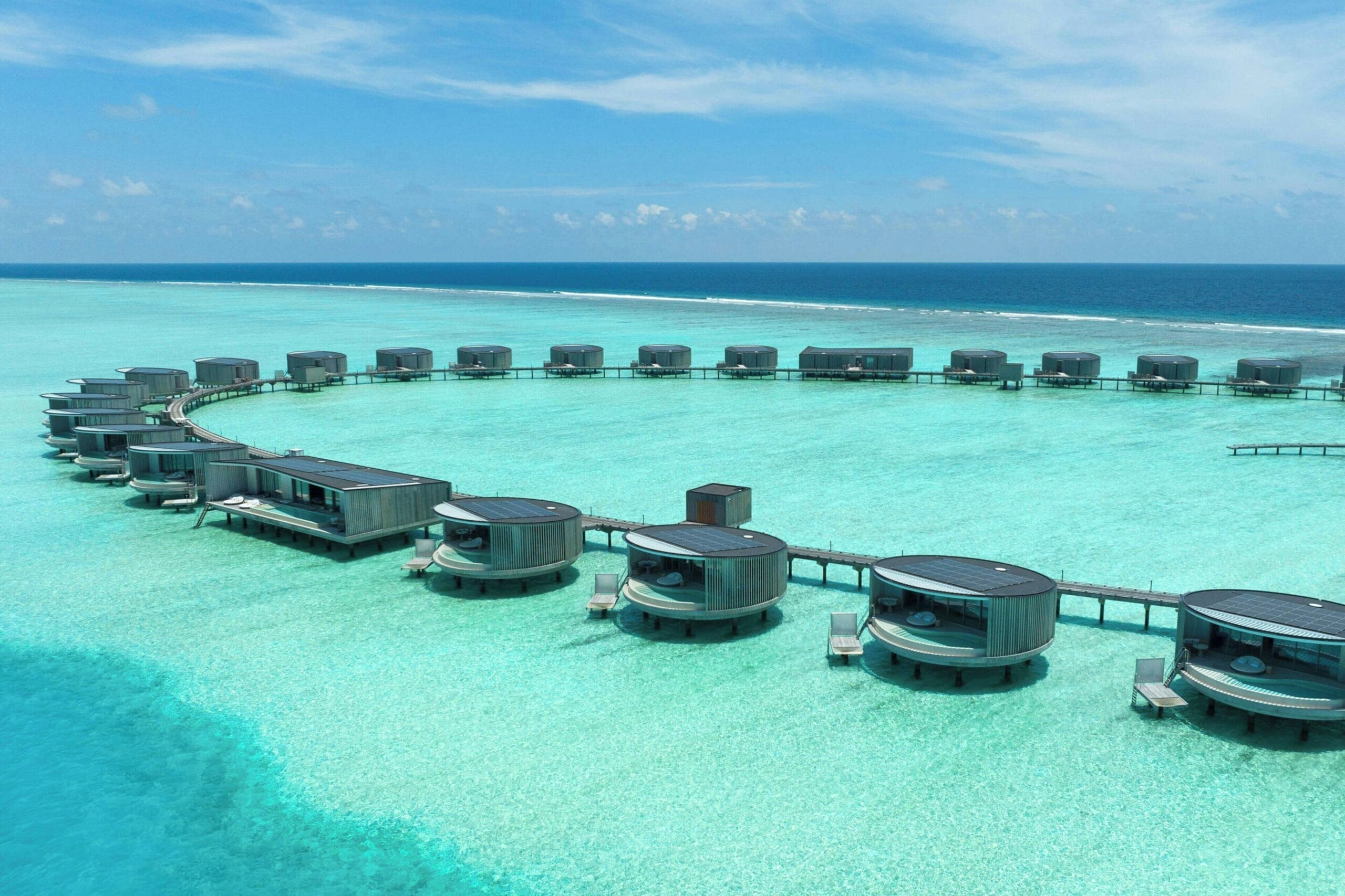 The Ritz-Carlton Maldives water villa interior with retractable panoramic windows over the lagoon
