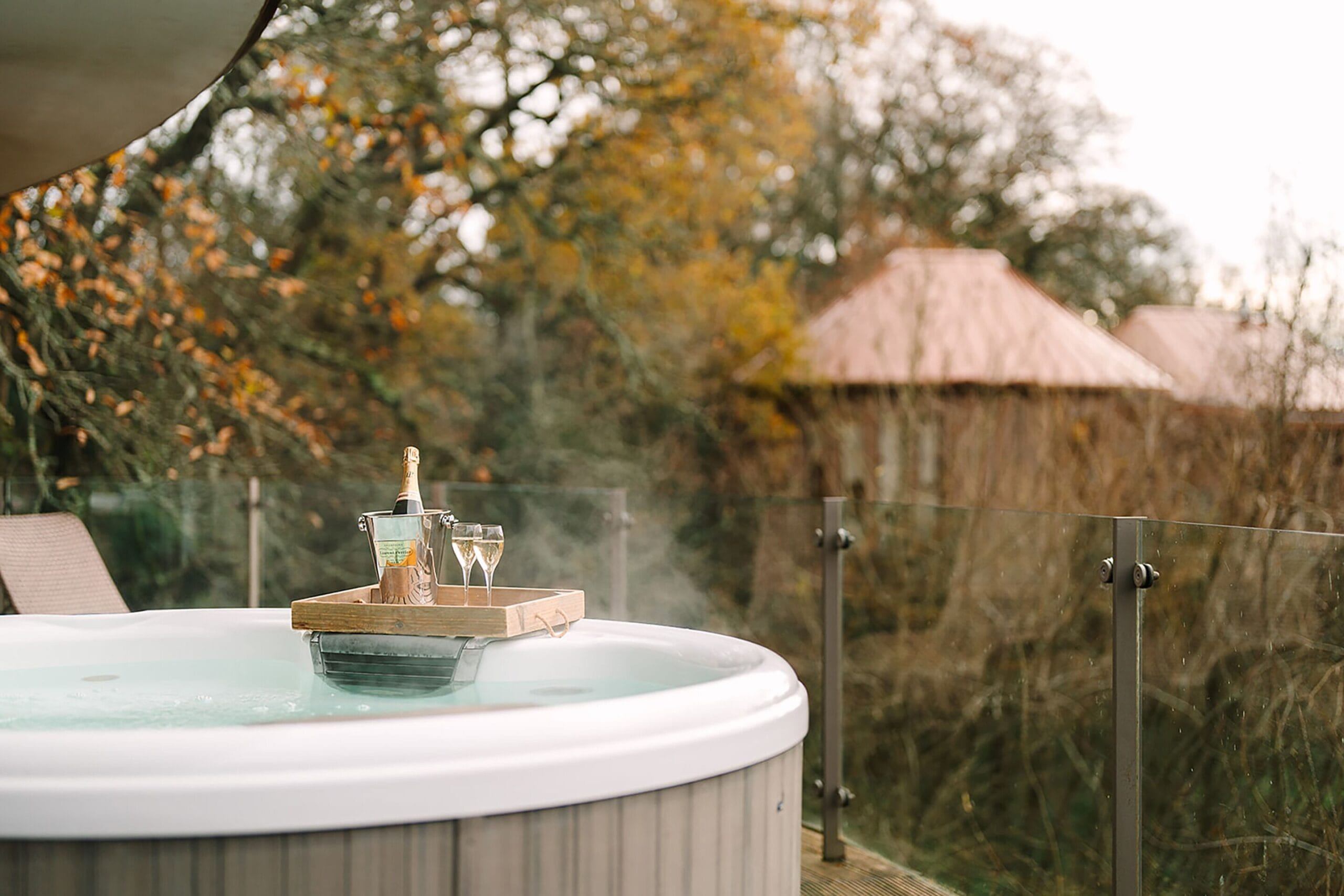Private balcony hot tub overlooking the New Forest canopy at a Chewton Glen treehouse suite, England