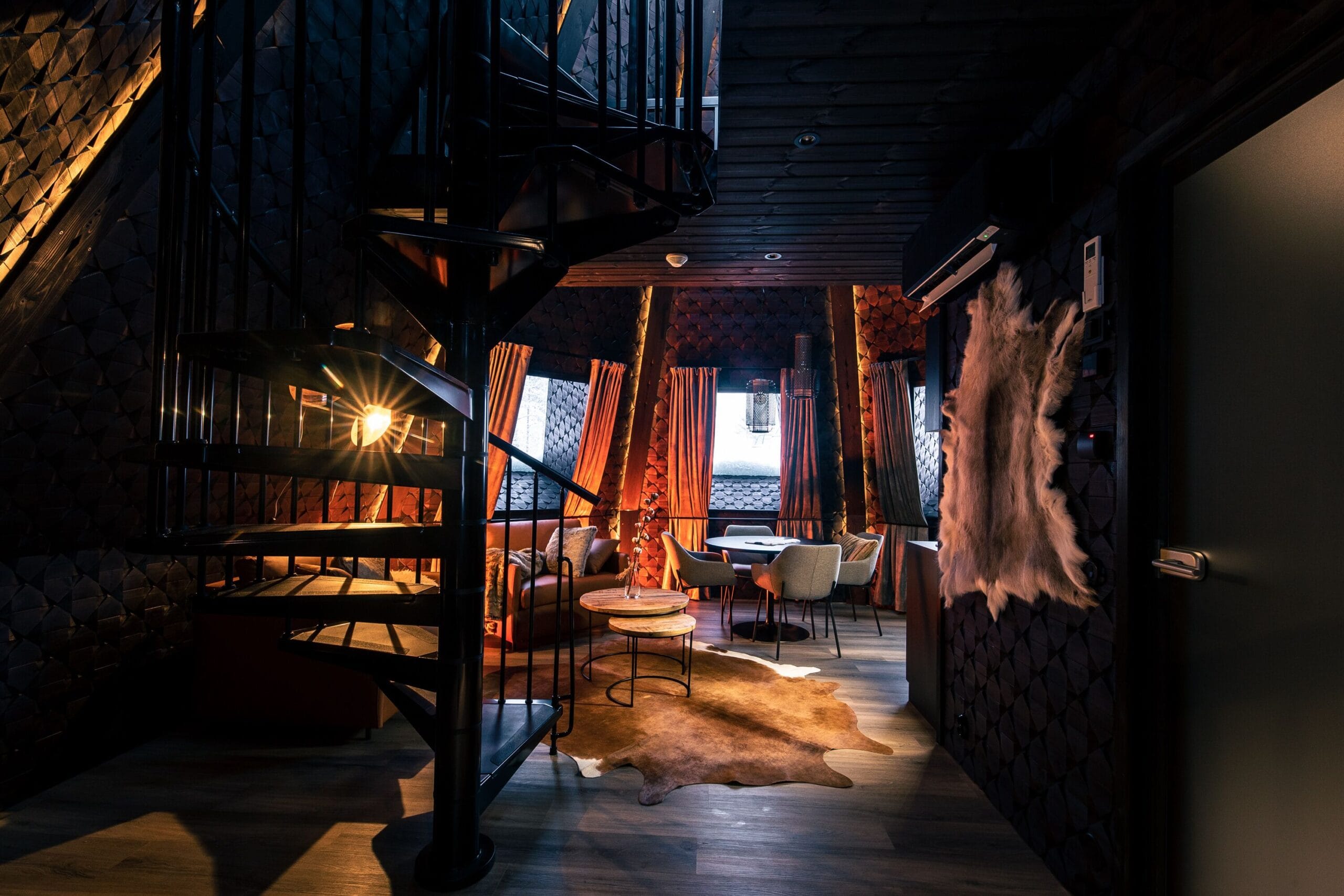 Aurora Cabin interior with king bed under a panoramic heated glass roof at Apukka Resort, Finnish Lapland