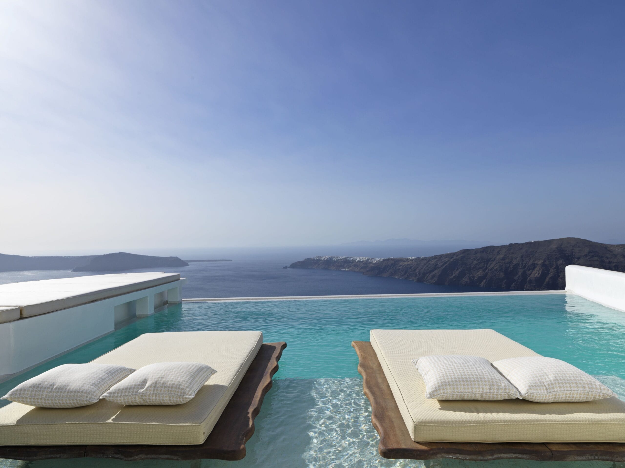 Cliffside suites and infinity pool with panoramic caldera views at Astra Suites, the best-view cave hotel in Santorini