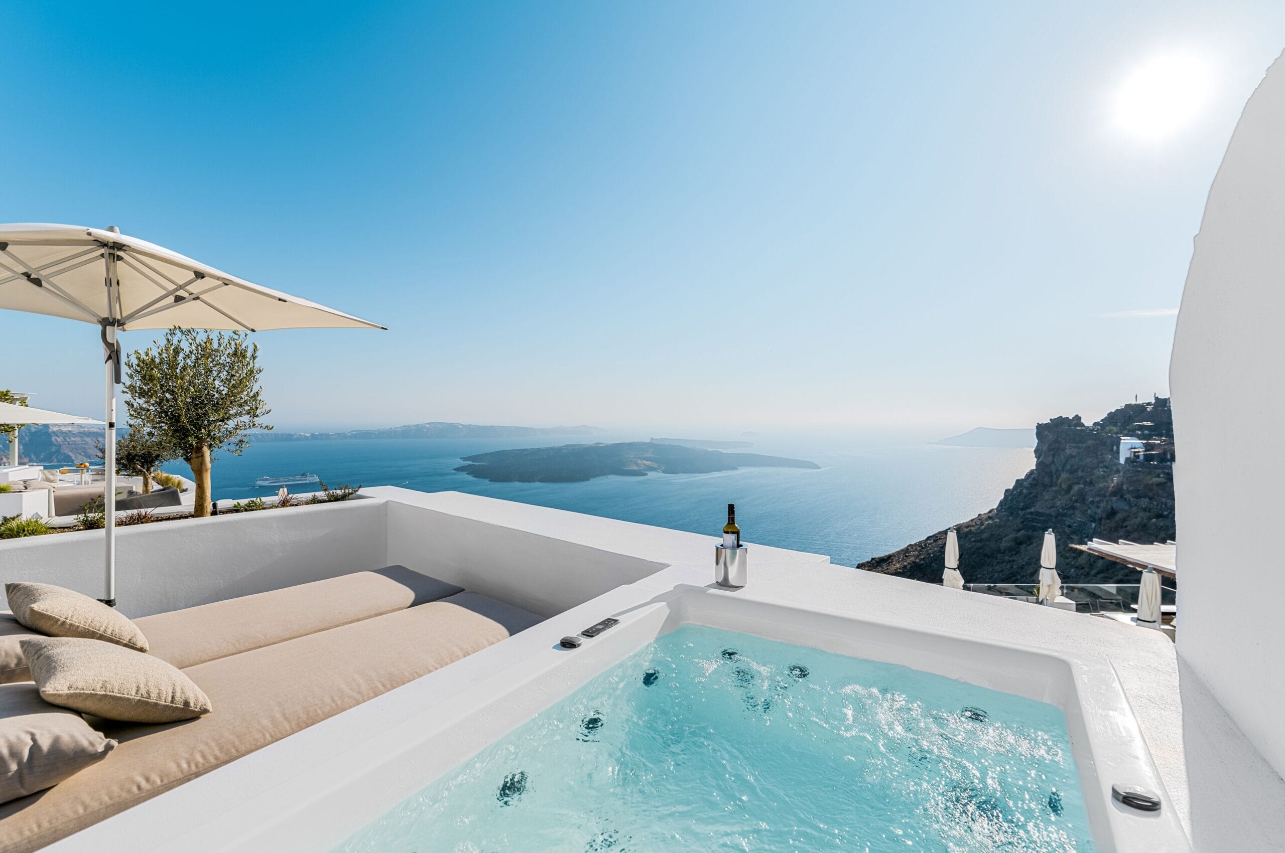 Cave suites carved into the caldera wall with infinity pool at Iconic Santorini, an authentic cave hotel in Imerovigli