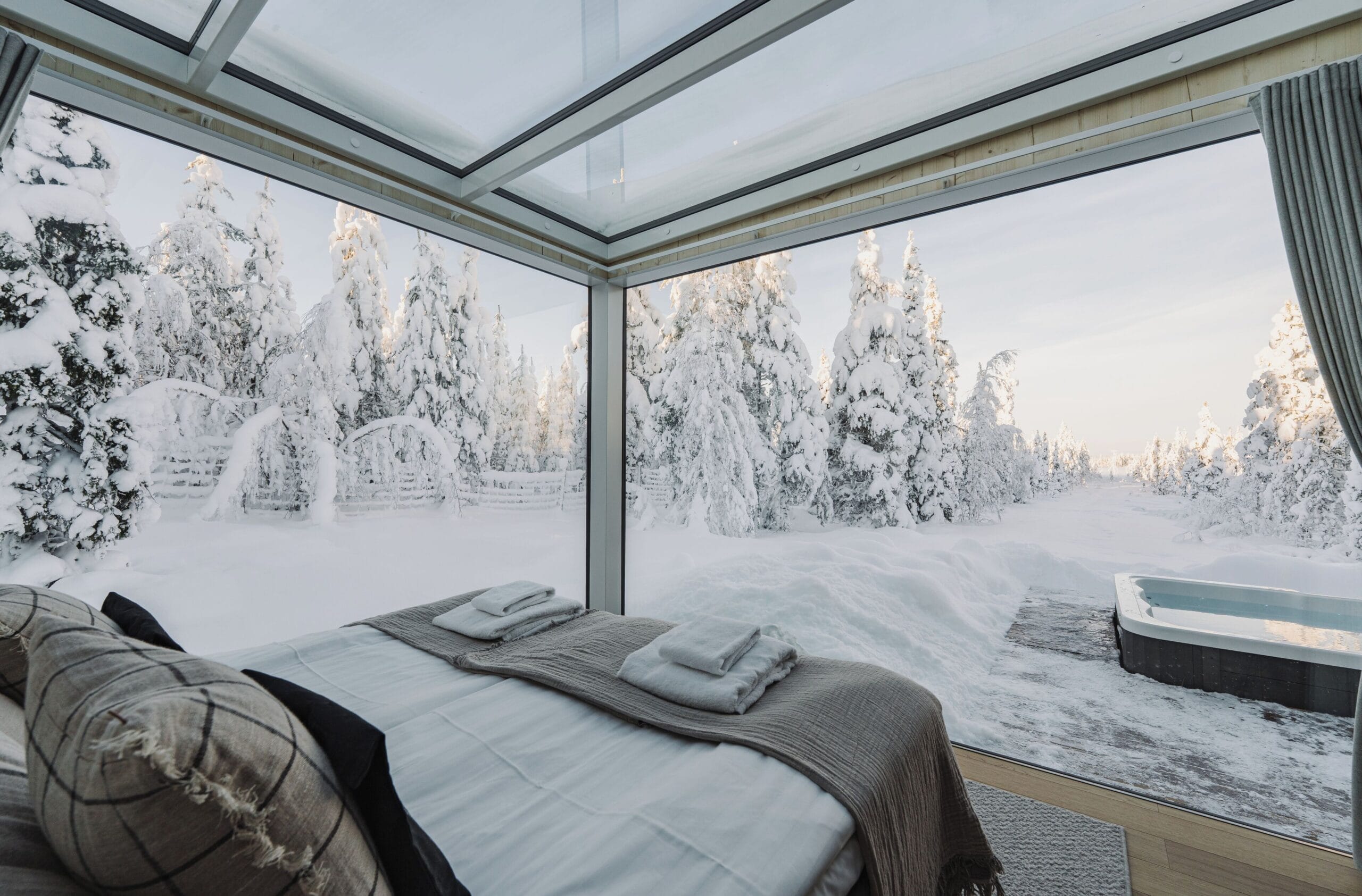 Sky View Cabin interior with motorised bed under a heated glass ceiling at Northern Lights Ranch, Finnish Lapland