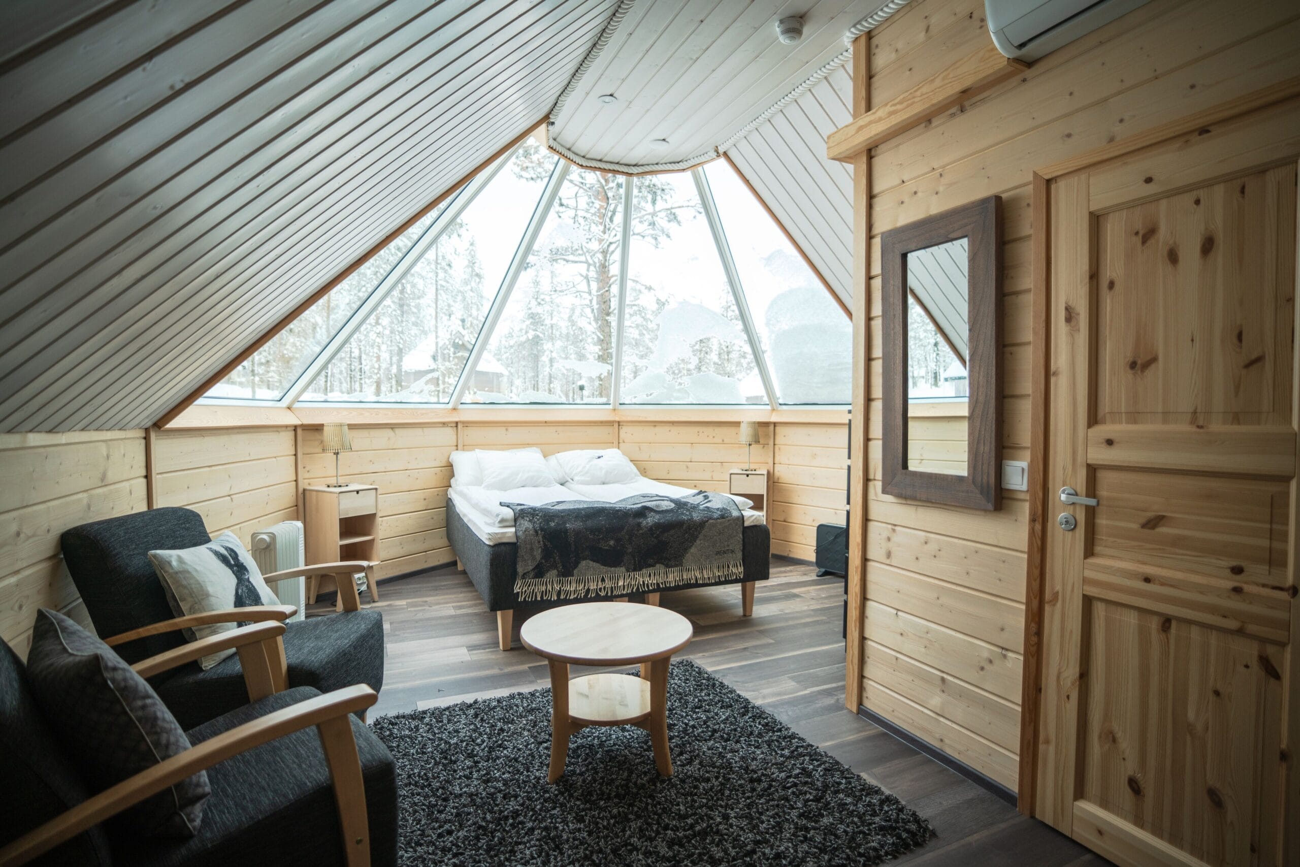Aurora Cabin interior with king bed under a laser-heated glass roof at Northern Lights Village Saariselka