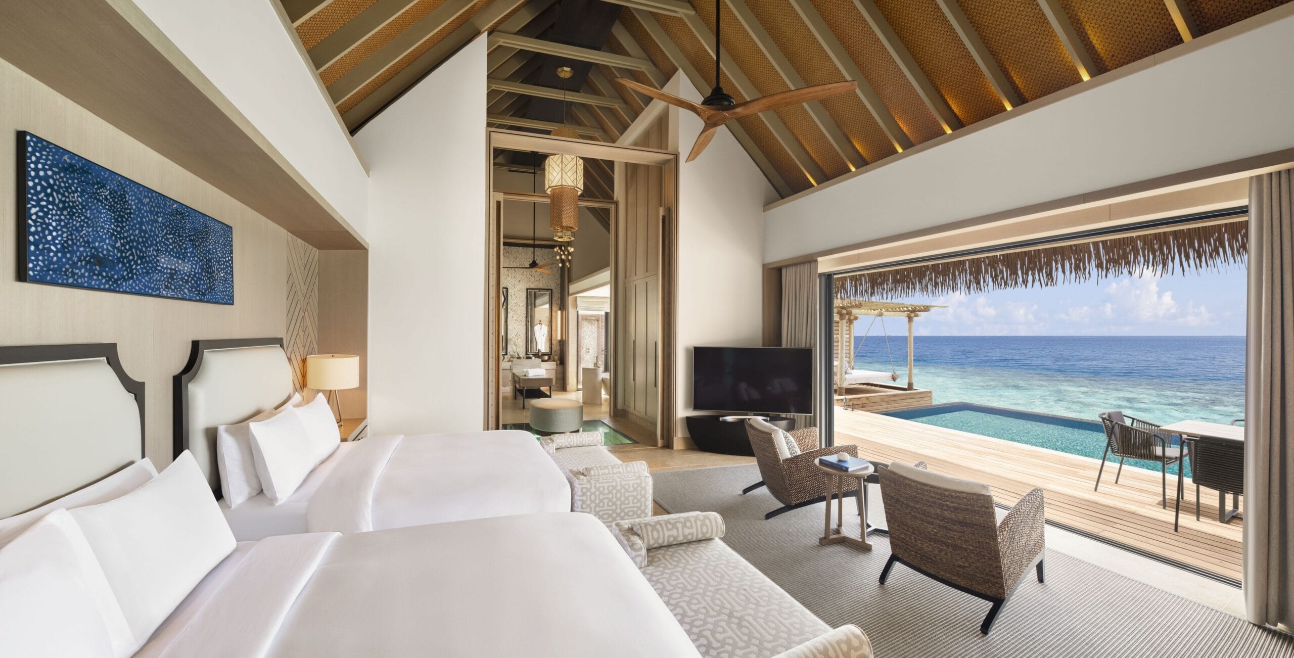 Waldorf Astoria Maldives water villa interior with full-size infinity pool over the lagoon