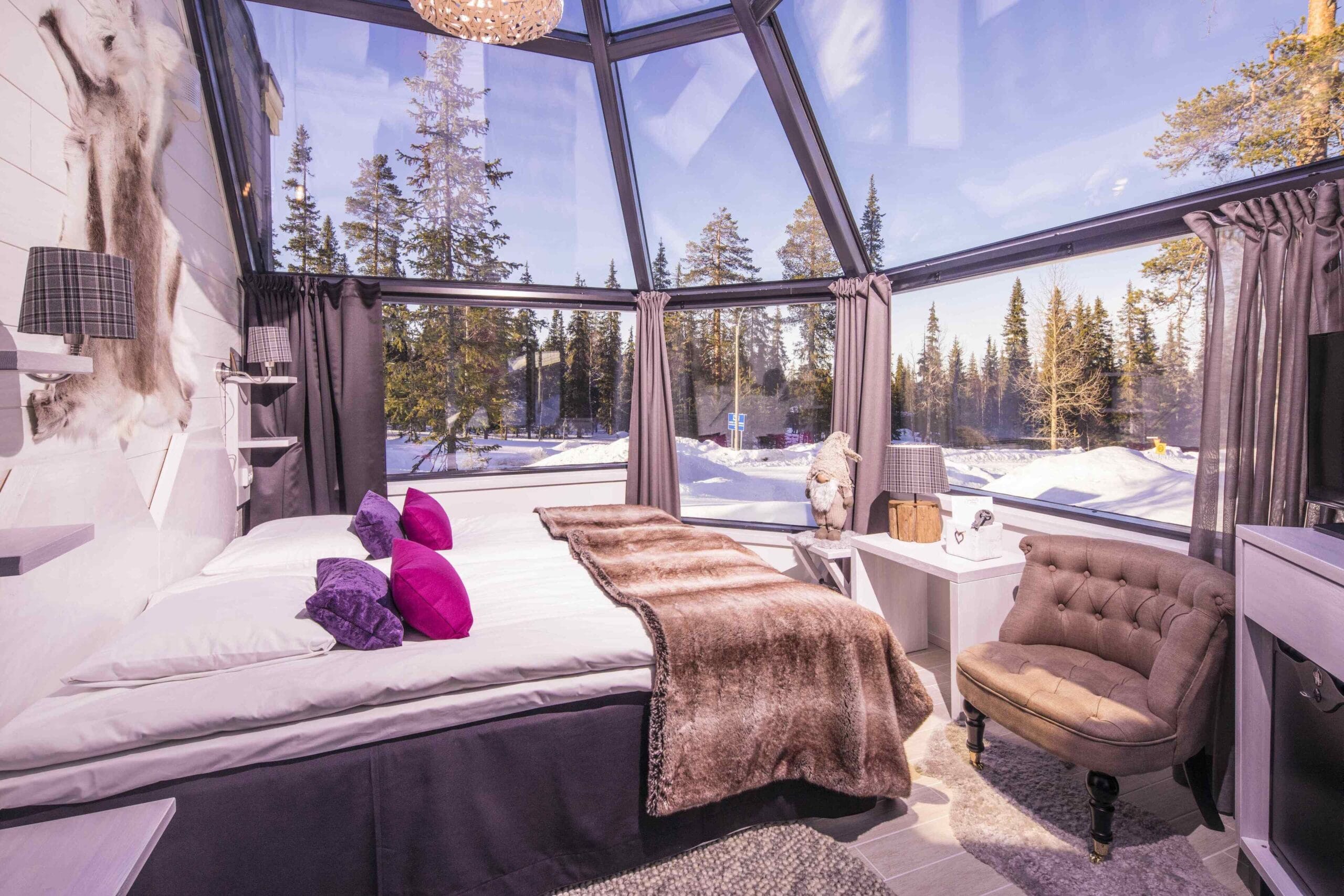 Lappish hut-style glass igloo under the Northern Lights at Santa's Hotel Aurora & Igloos in Luosto, Finland