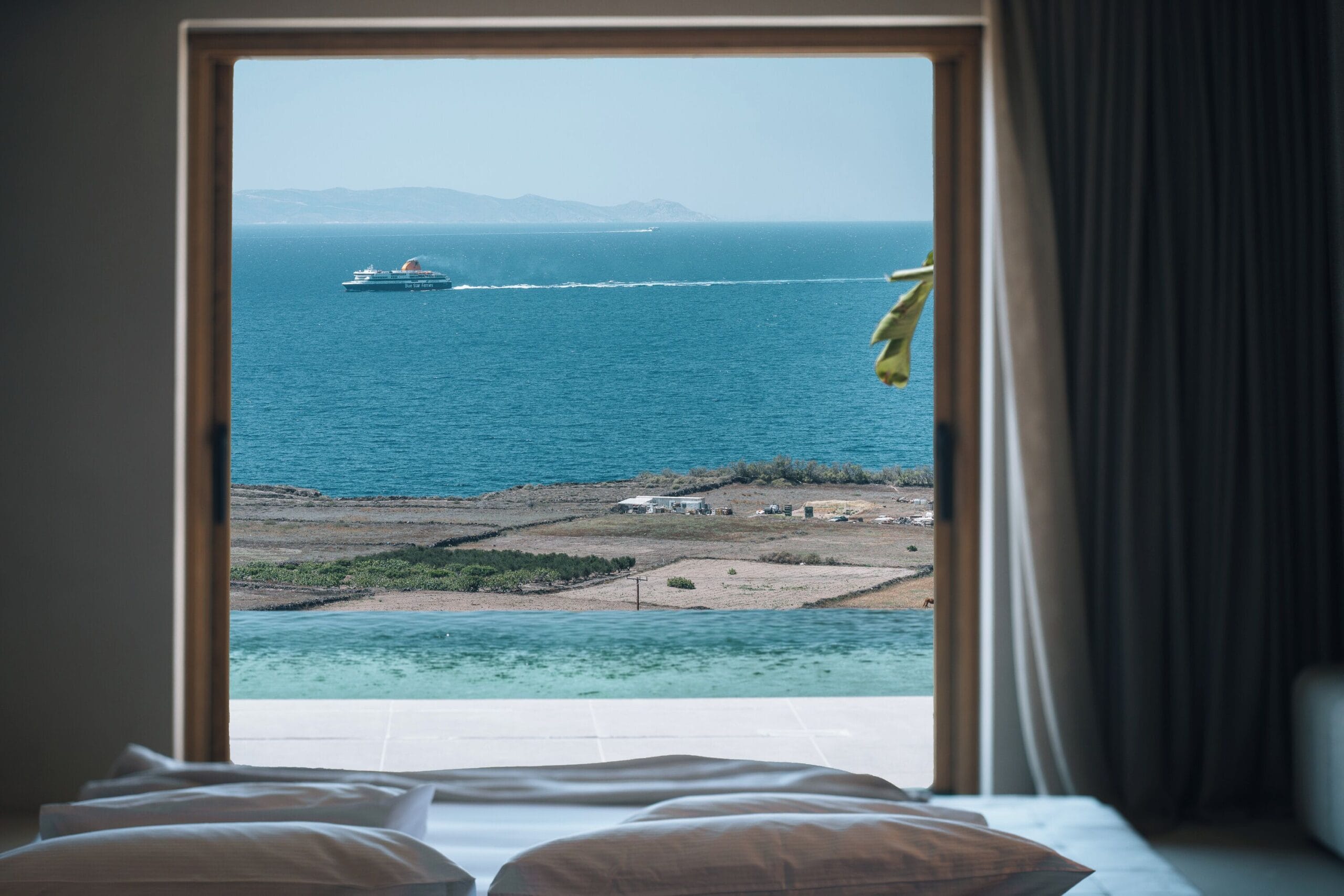 Andronis Arcadia bedroom opening onto a private pool terrace in Oia