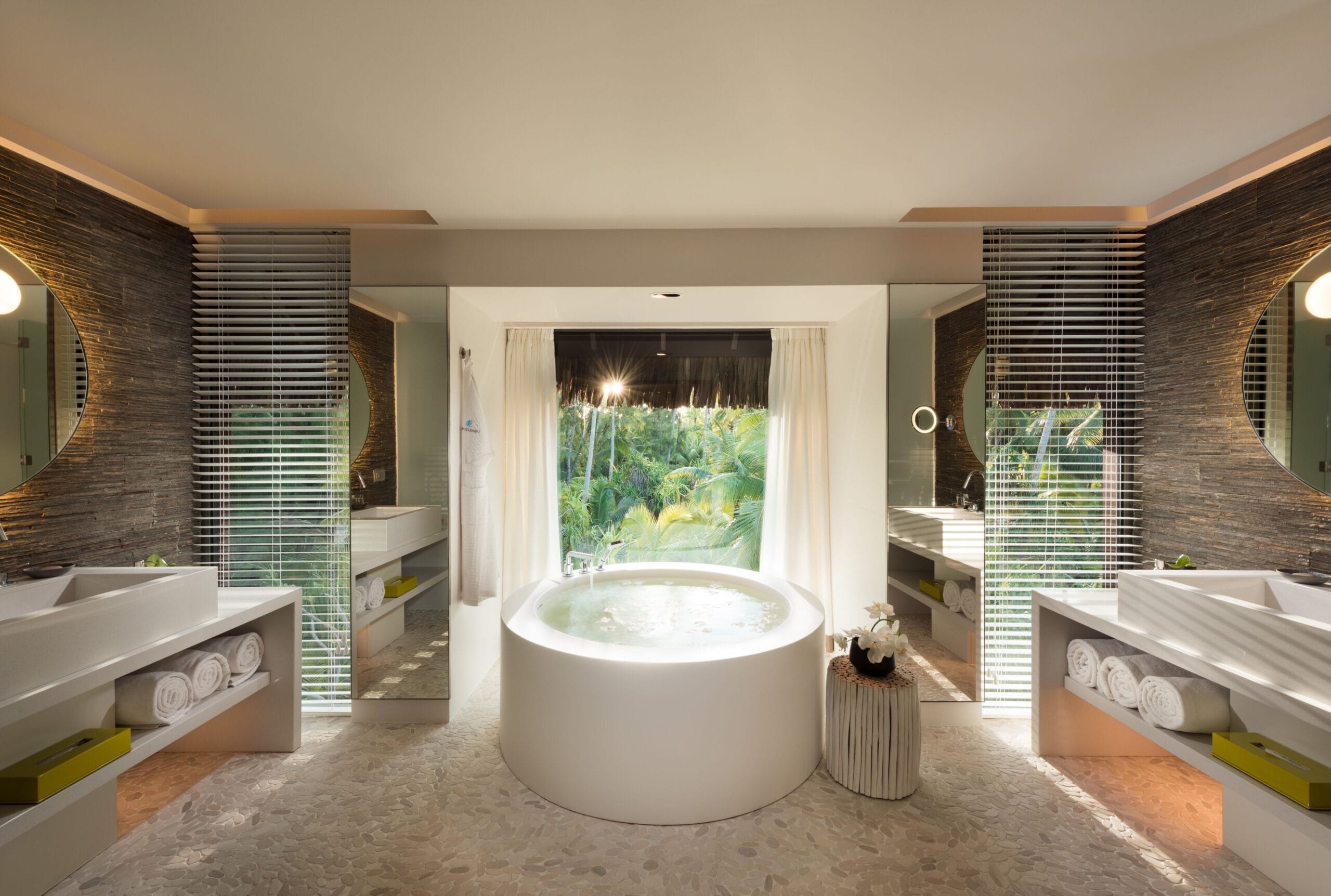 Luxury spa bathroom opening to the garden at a villa at The Brando, French Polynesia