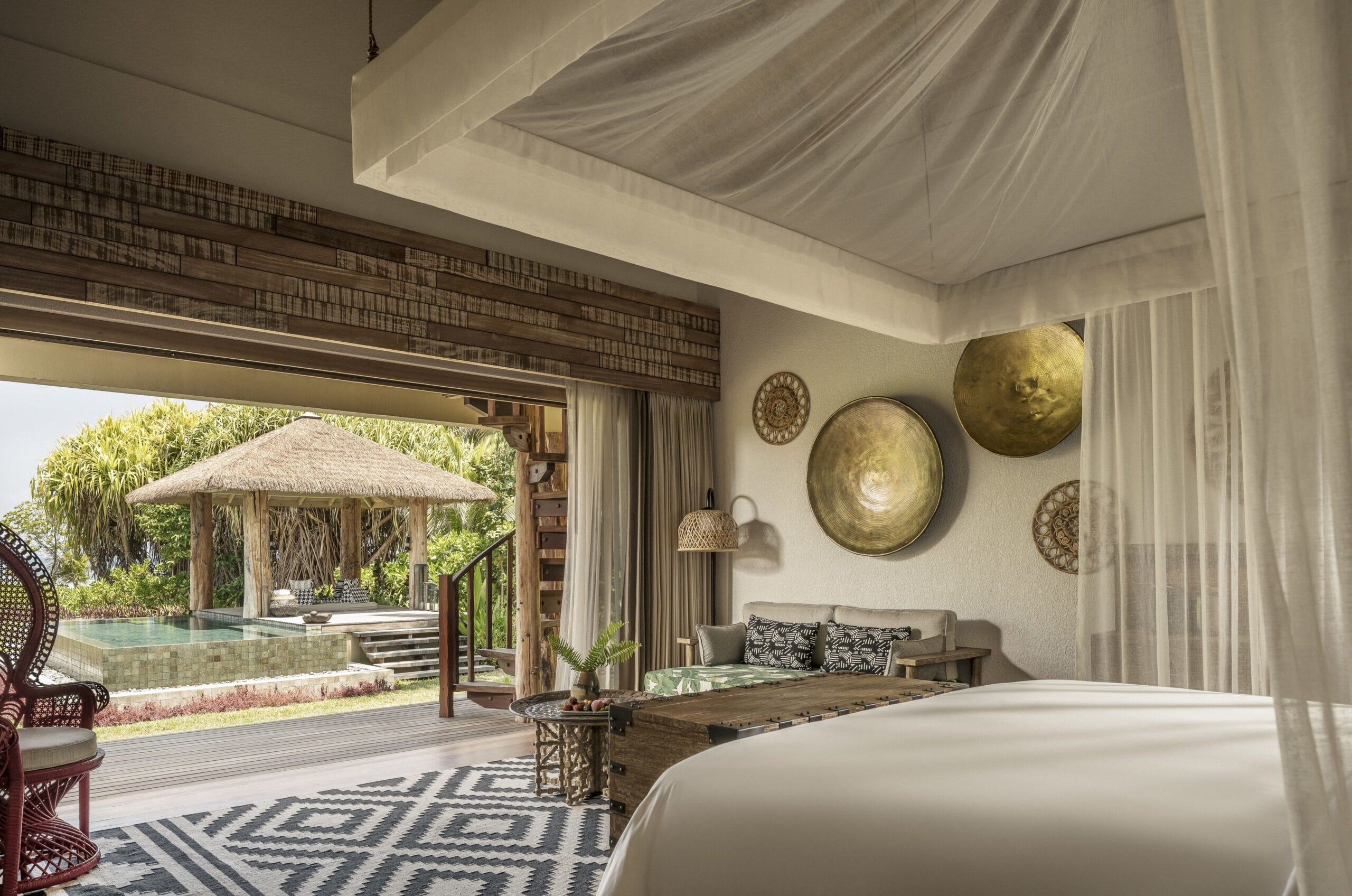 Luxury villa bedroom opening to the beach at Four Seasons Seychelles at Desroches Island