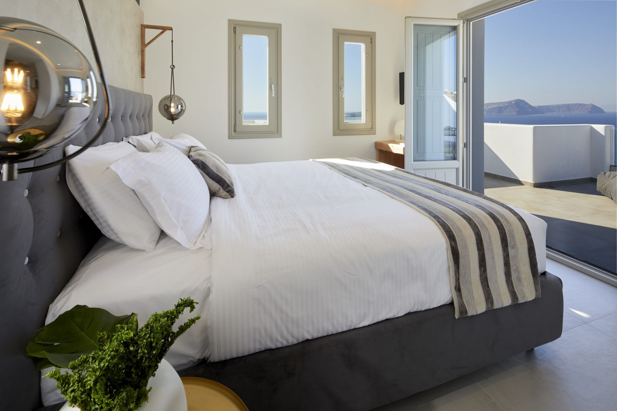 Phos The Boutique bedroom opening onto a private terrace and pool in Akrotiri