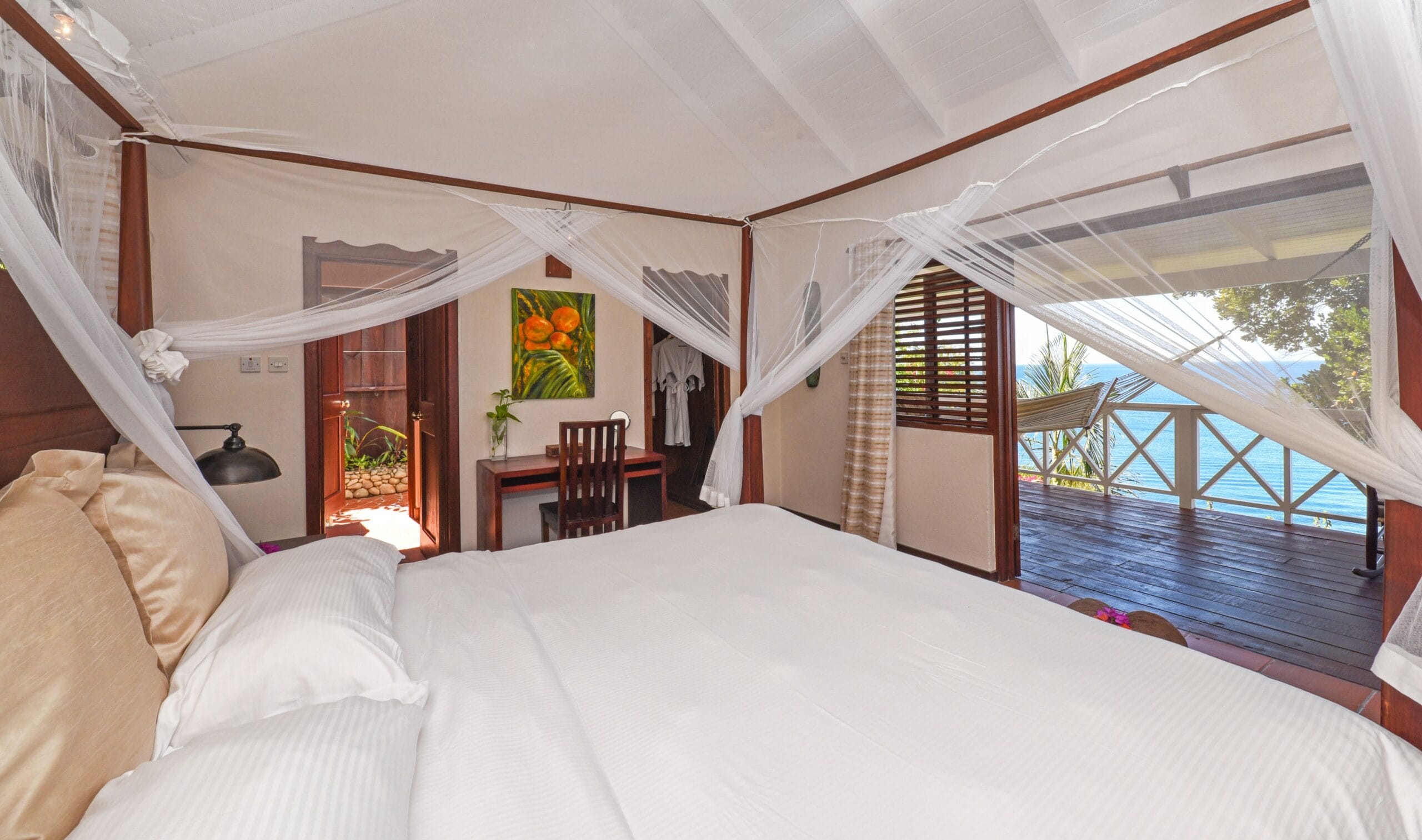 Four-poster bed with mosquito net in an ocean view cottage at Ti Kaye Resort, St. Lucia